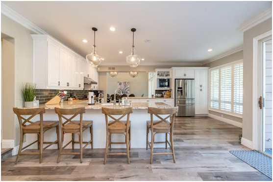 white kitchen with beige counters and four stools at the counter
